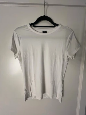 Vit tajt t-shirt  - En tajt vit t-shirt med rund hals och korta ärmar. Perfekt att matcha med jeans eller shorts för en clean look. Skriv om du undrar något💕