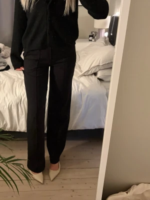 Svarta raka kostymbyxor (stretch) - Säljer ett par svarta kostymbyxor med rak passform och hög midja. Byxorna har pressveck framtill och är i ett mjukt, stretchigt material. 