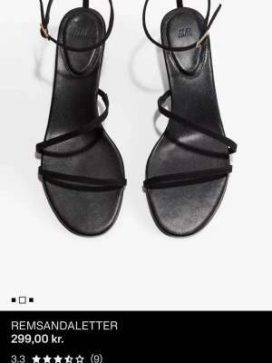 Svarta sandaler från H&M - Stilrena svarta sandaler från H&M med tunna remmar och fyrkantig tå. Sandalerna har en elegant design med smala band över foten och runt vristen, samt liten klack. Tillverkade i syntetmaterial med matt finish.