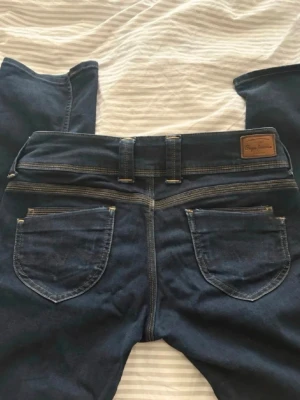 Mörkblåa lågmidjade pepe jeans - Säljer ett par väldigt lågmidjade jeans i storlek 27/32💓Jag har sytt om jeansen till bootcut men inget man tänker på🥰 Hör av er kring frågor eller om fler bilder!!💕 Pris går alltid att diskutera!!