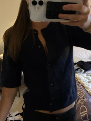 Mörkblå fluffig kofta med knappar - Säljer en stickad t-shirt med knappt ifrån gina tricot, strl 158/164💞💞 Inga tecken på användning 