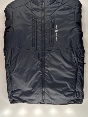 Svart dunjacka från Sail Racing - Stilren svart dunjacka från Sail Racing med två vertikala bröstfickor med dragkedja och logga på vänster sida. Den är i ett bra skick och är perfekt nu inför våren. Tags medföljer ej. Pris kan diskuteras och den skickas samma dag. Bara att höra av dig om du är intresserad.