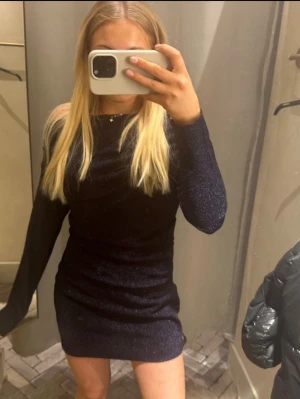 Glittrig mörkblå klänning från H&M - Snygg glittrig mörkblå kortklänning från H&M. Sitter som S.