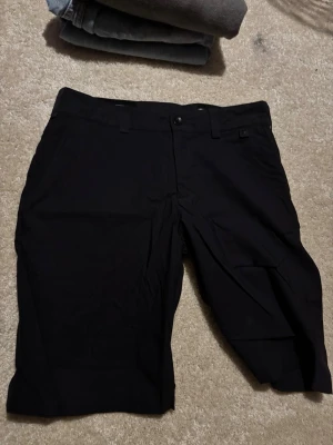 Svarta shorts från Peak Performance - Snygga svarta shorts från Peak Performance i modellen M Player Short. Klassisk design med bekväm passform och diskret logga. Perfekta för sommardagar eller träning. Gjorda i ett slitstarkt material som känns skönt mot huden.