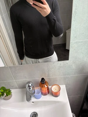 Svart basic tröja med rund hals från John Henric - En stilren svart tröja med rund hals och långa ärmar. Tröjan har en slim fit passform och är tillverkad i ett mjukt, stretchigt material som sitter skönt på kroppen. Perfekt för dig som gillar en clean och enkel look. Vill ni ha mer bilder bara hör av er.