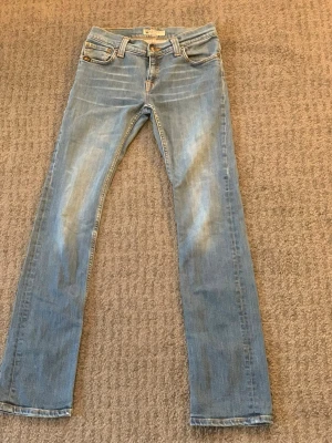 Ljusblå bootcut jeans från Replay - Snygga ljusblå jeans från Replay med bootcut passform och slitna detaljer framtill. Klassisk femficksmodell med Replay-logga på bakfickan. Tillverkade i mjuk denim som ger en avslappnad look. Perfekta för dig som gillar en retro vibe.