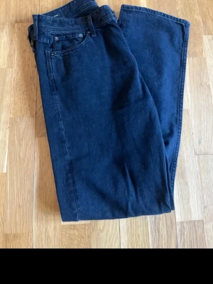 Svarta raka jeans Jack & Jones - Snygga svarta jeans från Jack & Jones med rak passform och klassisk femficksdesign. Jeansen har en enkel look utan slitningar och är tillverkade i ett mjukt denimtyg. Perfekta för dig som gillar stilrena och tidlösa jeans.