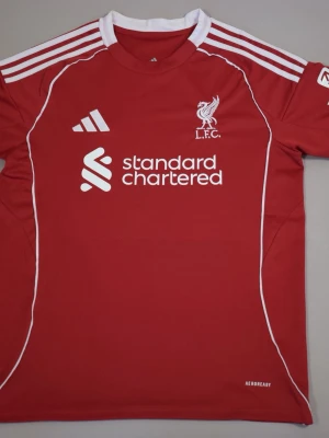 Liverpool Hemmakit 25/26 - Säljer min Liverpool hemmatröja från denna säsongen. Skick är 4,5/5 och storleken Medium. Har inte använd den mycket alls då jag har 2 andra ja använder istället, därav de bra skicket. Original påse och tag finns och fås med vid köpet.