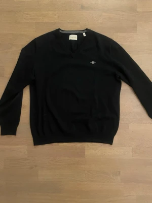 Stickad tröja från GANT - Snygg svart stickad tröja ifrån Gant, helt oanvänd.