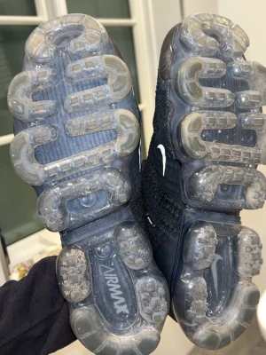 Nike Air VaporMax Flyknit 2 - Dem är ÄKTA, köpta för 3000, knappt använda Svarta Nike Air Vapormax sneakers med stickad ovandel i mesh och genomskinlig, bubblig sula. Klassisk Nike Swoosh på sidan och Vapormax-logga på plösen. Skorna har svarta skosnören och en sportig, modern look.