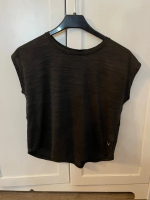 Svart träningstopp från soc - Svartgrå träningstopp från soc med rund halsringning och avslappnad passform. Tillverkad i ett lätt och mjukt material som passar perfekt för träning eller en chill look. Diskret logga nertill på framsidan. Använd ändast en gång. Pris kan diskuteras. OBS! Köparen står för frakt.