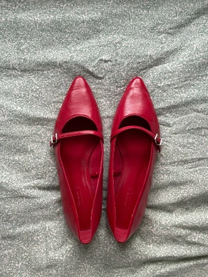 Röda ballerinaskor - Säljer ett par snygga röda ballerinaskor med spetsig tå från Pull & Bear