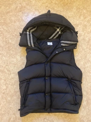 Burrbery väst  - Tja säljer min burrbery väst size S väldig snygg och skön i luvan och snyggt med rutorna i luvan. Den ända defekten som syns på bilden är fick dragkedjan som delats på mitten typ men det går å fixa har bara inte orkat perfekt nu till våren priset är inte fast så går att pruta !