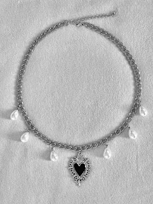 Halsband med pärlor och hjärthänge - Snyggt halsband i silverfärgad rostfritt stål med droppformade vita pärlor och ett detaljerat hjärthänge i svart och silver. Kedjan är grov och har justerbar längd. Perfekt för dig som gillar statement-smycken med vintagekänsla.