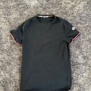 Moncler T-Shirt - Snygg svart t-shirt från Moncler med slim fit passform. Perfekt t shirt till sommar och vår!     Hör av er vid frågor 