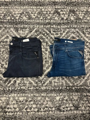Replay jeans i svart och blå denim - Två par snygga jeans från Replay, ett par i svart och ett par i blå. Båda har Replay-logga på fickan. Jeansen är i storlek arna: Svart: W31, L34. / Blå: W32, L32. Hör av er vid eventuella frågor eller funderingar!!