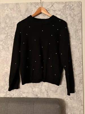 Svart stickad tröja med pärlor - Snygg svart stickad tröja med pärlor. Tröjan är i använt skick och storlek S 