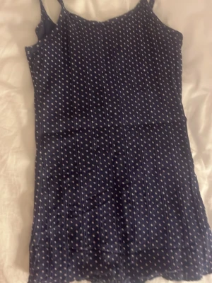 Mörkblå prickig linnetopp - Snygg mörkblå linnetopp med vita prickar och smala axelband. Toppen har en figurnära passform och är perfekt. Materialet känns mjukt och lätt mot huden. Det står inget i linnet om storlek eller märke men det är ungefär S och jag köpte det second hand från Polen.🤗(det är vita prickar men det har blivit lite urtvättat)
