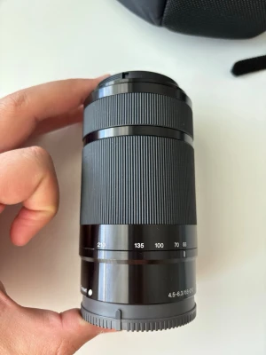 Sony E 55-210mm f/4.5-6.3 OSS objektiv - Säljer ett svart Sony E 55-210mm f/4.5-6.3 OSS telezoomobjektiv. Objektivet har en slimmad, cylindrisk form med räfflad zoomring och tydliga brännviddsmarkeringar. Passar till Sony E-mount kameror och har optisk bildstabilisering.
