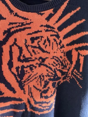 Tiger tröja - En marinblå stickad tröja med stort oranget tiger tryck på bröstet