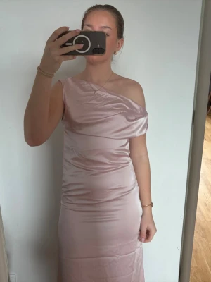 Ljusrosa satin one shoulder klänning - Snygg ljusrosa långklänning i satin med one shoulder-design. Klänningen har en figurnära passform och slät yta som ger en elegant look. Perfekt till bal, bröllop och middagar💖