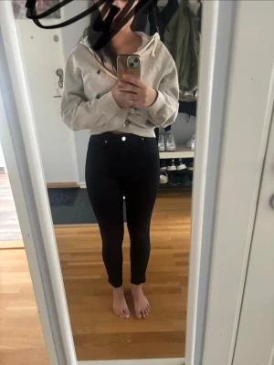Svarta skinny jeans med hög midja - Säljer ett par svarta skinny jeans med hög midja och klassisk femficksdesign. Jeansen har smal passform hela vägen ner och stängs med knapp och dragkedja. Perfekta till en avslappnad eller trendig look.