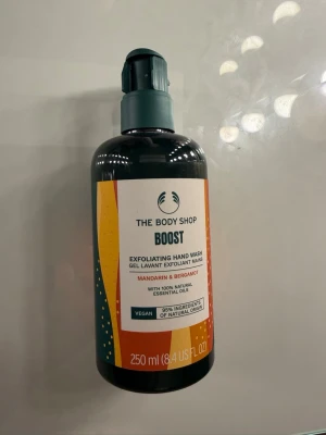 The Body Shop Boost handtvål - Exfolierande handtvål från The Body Shop i serien Boost med doft av mandarin och bergamott. Innehåller 100% naturliga eteriska oljor och 95% ingredienser av naturligt ursprung. Vegansk formula i en 250 ml pumpflaska.