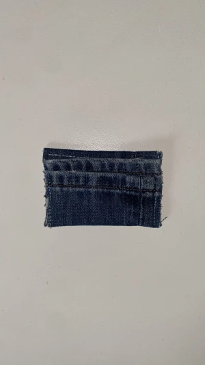 Plånbok - En unik liten plånbok gjord av återvunnen blå denim. Rektangulär form med synliga sömmar och råa kanter för en cool, avslappnad look. Perfekt för kort eller mynt. Plånboken är gjord av vårat uf företag på 5 tjejer som heter deni_mdesign.