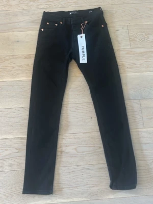 Svarta purple jeans - Snygga svarta skinny jeans från Purple med klassisk femficksdesign och kopparfärgade nitar. Jeansen har hög midja och är tillverkade i ett stretchigt denimtyg som sitter tight hela vägen ner. Perfekta för en trendig och clean look. Helt ny provad en gång, säljer eftersom de var lite tightare än vad jag trodde.