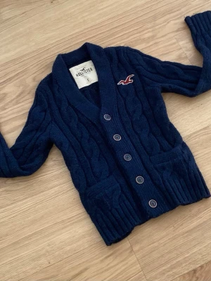 Hollister Cardigan - Säljer en riktigt fet Hollister Cardigan. Denna är välkänd och många söker den. Skicket är 10/10. Storleken är S. Priset kommer ligga på 599kr men kan sänkas.