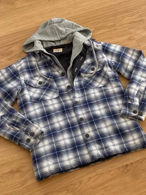Blåvit rutig overshirt  - Säljer en riktig snygg vit blå rutig overshirt. Skicket är 10/10. Storleken är S. Priset kommer ligga på 1099kr.