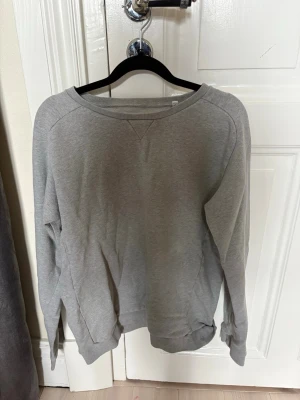 Grå basic sweatshirt - Enkel grå sweatshirt med rund halsringning och ribbade muddar. Tröjan har en klassisk passform och är tillverkad i mjukt bomullsmaterial. Perfekt för en avslappnad och stilren look. Krympt lite i tvätten 