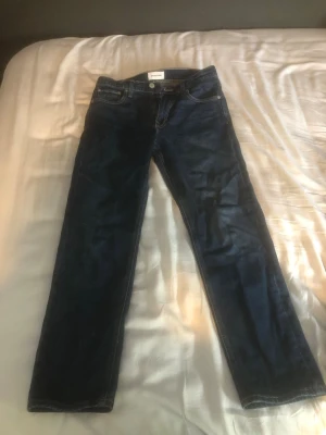 jack&jones jeans 28/30 - Snygga mörkblå jeans från jack&jones med klassisk femficksdesign och raka ben. Jeansen har en enkel look och är tillverkade i bomull, perfekta för en stilren vardagsoutfit. relaxed/chris. pris ej hugget i sten!!