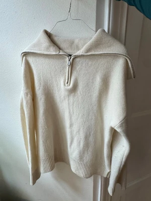 Krämvit stickad tröja med dragkedja - Supersnygg och unik stickad tröja från Massimo Dutti. Materialet är ull så den är väldigt skön och i bra kvalitet