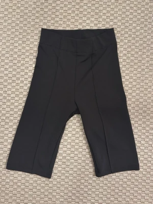 Svarta cykelshorts i stretchigt material - Svarta cykelshorts med hög midja och stretchigt material. Perfekta för träning eller en sportig look. Klassisk design utan synliga detaljer eller mönster.