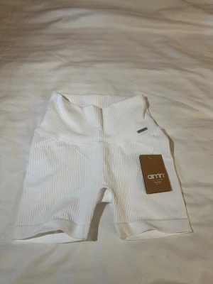 Vita ribbade shorts från Aim'n - Vita ribbade shorts från Aim'n med hög midja och tight passform. Shortsen är stretchiga och är oanvända.