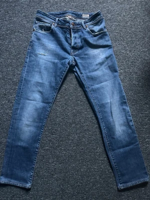 Jacob cohen jeans - Snygga blå slim fit jeans från jacob cohen med klassisk femficksdesign och lätt slitna detaljer på låret. Jeansen har normal midja, dragkedjegylf och är gjorda i mjuk denim med lite stretch för extra komfort.
