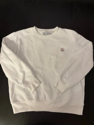 Vit sweatshirt från Moncler - Snygg och oanvänd vit sweatshirt från Moncler. Står M men är lite mindre i storlek. Perfekt och clean till sommaren. Skriv vid frågor! 