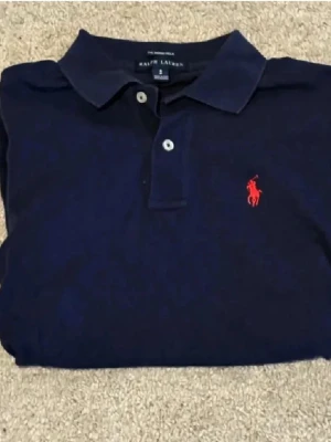 Ralph Lauren piké i storlek S - Säljer en mörkblå Ralph lauren piké i storlek S. Sitter perfekt i storleken. Använd endast ett fåtal gånger så är i princip i nytt skick. Hör av er om ni undrar något! 