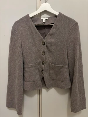 Stickad kofta - Gråbrun stickad kofta med fyra stora knappar framtill och två  fickor, använd fåtal gånger