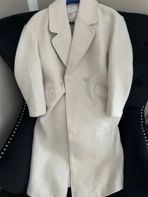 Beige ullkappa med slagkrage - Stilren beige kappa i ullmix med klassisk slagkrage och dubbelknäppning. Stor i storlek och passar från xs-L💕 original pris 699kr! 