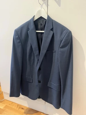 Kostym Grå/Blå H&M - Grå/Blå kostym från H&M. Storlek M på kavaj. Storlek 46 på byxor. Mycket få tecken på användning, inga synliga fläckar.   Hör av er om det finns frågor eller önskas fler bilder!