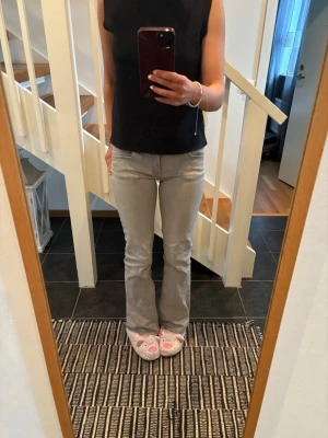 Ljusgrå bootcut jeans - Säljer ett par ljusgrå bootcut jeans ifrån Gina med klassisk femficksmodell och normal midja. Jeansen har en snygg tvätt och är perfekta för dig som gillar en avslappnad men ändå trendig stil. Passar till det mesta och är riktigt bekväma/stretchiga🥰