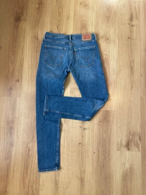 Levi's 512 - Säljer ett par klassiska blå Levi's 511 slim jeans med fem fickor och snygga kontrastsömmar. Pris kan diskuteras.