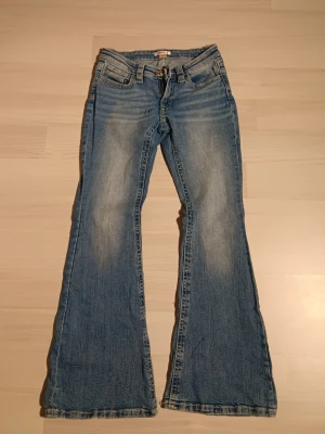 Blå bootcut jeans - Säljer ett par blå bootcut jeans. Bakfickor med detaljer. Jeansen har låg midja.. Perfekta för dig som vill ha ett par jeans med lite bootcut. Har används 2-3 gånger då dem var för korta för mig. Pris kan alltid diskuteras🫶