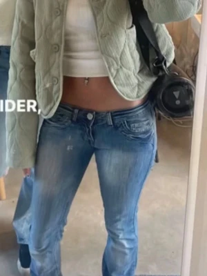 jacka - Trendig ljusgrön cardiganjacka med quiltat mönster och stora framfickor. Jackan har rund halsringning, knäppning framtill med stora knappar och är tillverkad i ett mjukt tyg. Perfekt för lager på lager och ger en cool vibe till din outfit.