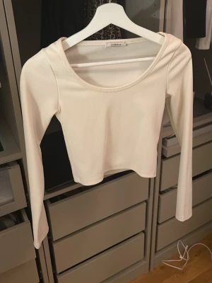 Vit croppad långärmad topp Chiquelle - Säljer en stilren vit croppad topp från Chiquelle. Toppen har lång ärm, rundad halsringning och är tillverkad i ett mjukt, stretchigt material som sitter snyggt på kroppen.💞💞