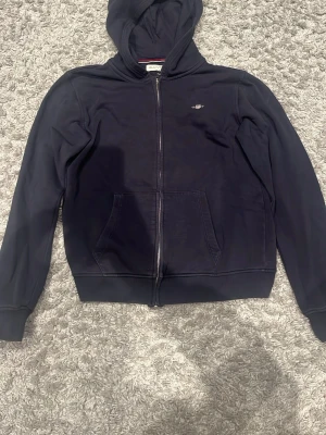 Gant Zip Hoodie || Storlek XS-S  - GANT zip hoodie i blått, använd men i väldigt bra skick. Knappt märkbart slitage, inga fläckar eller hål. Bekväm passform med huva och fickor på sidorna. Storlek: (XS-S) Nypris ca 1000 kr. OBS priset är inte hugget i sten. Om du har frågor eller vill ha mer bilder tveka inte på att skriva ett PM. 