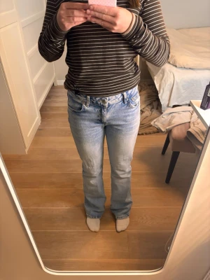 Ljusblå bootcut jeans med normal midja - Säljer ett par ljusblå jeans med normal midja. Jeansen är booutcut och är använda ganska sparsamt. Materialet är denim i bomull. Storlek 152