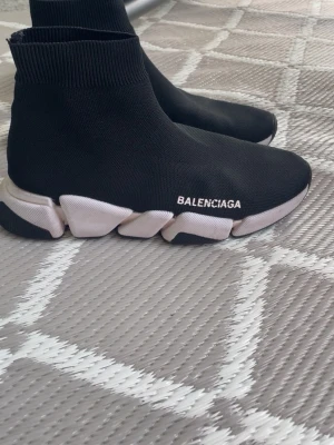 Balenciaga Speed Trainer svarta sneakers - Svarta Balenciaga Speed Trainer sneakers med vit chunky sula och stickad ovandel i textil. Strumpliknande passform med ribbad kant och tydlig logga på sidan. Snygg och futuristisk design som sticker ut.